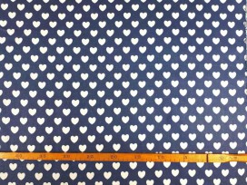 Een jeansblauwe canvas stof bedrukt met witte hartjes. De hartjes hebben een doorsnee van 17 mm. 100% katoen 1.50 mtr. br.