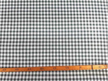 Een met donkergrijze boerenbont ruit bedrukte canvas, die iets wat stug aanvoelt.  Het ruitje is 7 x 7 mm. 100% katoen 1.50 mtr.