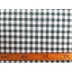 Een met donkergrijze boerenbont ruit bedrukte canvas, die iets wat stug aanvoelt.  Het ruitje is 7 x 7 mm. 100% katoen 1.50 mtr.