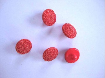 Een rode kunststof bloemknoop met een doorsnee van 12 mm.