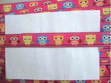 Pink kleurig sierband met gele, rode, oranje en Aquakleurige uiltjes.  15 mm breed