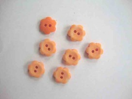 Een oranje kunststof bloemknoop met een doorsnee van 12 mm