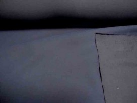 Een diep donkerblauwe jassenstof. De onderkant is glad de bovenkant iets geruwd. Winddicht, niet geheel waterdicht. Polyester  1