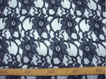 Jacquard kant stof effen zwart met bloemenstiksel wat erop ligt.  Rekt in de breedte en voelt zacht aan.  140 cm breed